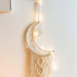 Detailed view of crescent moon woven macrame dream catcher with warm LED lights and tassels
