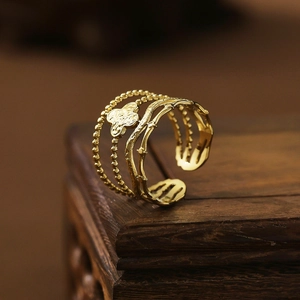 Macro shot of 18k gold plated stainless steel ring with clover motif and open design