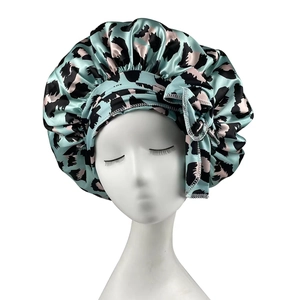 Mint green leopard print satin silk sleep bonnet with wide ties on a mannequin