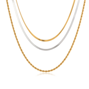Detailed shot of layered stainless steel jewelry with gold rope and silver snake chains