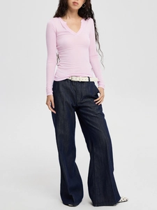 Slim fit pink V-neck long sleeve knit top paired with wide-leg jeans and white belt