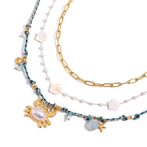 Collana multistrato dorata con perla, fiore di conchiglia e ciondoli marini granchio e stella