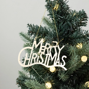 Plaque Merry Christmas dorée suspendue au sapin avec éclairage d'ambiance chaleureux