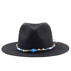 Detail of black straw fedora hat featuring a bohemian colorful beaded decorative band
