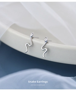 Macro detail of S925 sterling silver snake earrings with sparkling zircon gemstone setting