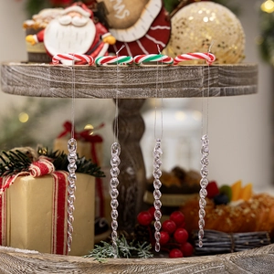 Clear acrylic spiral icicle ornaments hanging on a wooden tray with festive background
