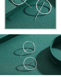 Detailed close-up of geometric silver round earrings on a premium green background