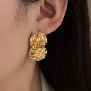 Double circle titanium steel earrings with radial texture on a female model
