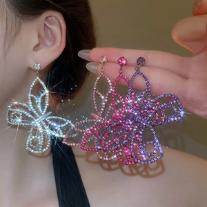 Macro detail of butterfly crystal drop earrings in silver, pink, and purple color options