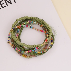 Detail of bohemian multilayer beaded bracelets with green and colorful resin beads