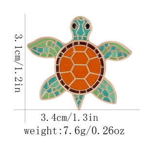 Detailed view of turtle enamel brooch with dimensions 3.1cm by 3.4cm on white background