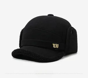 Detail view of winter baseball cap with plush ear flaps and golden ny logo on black wool