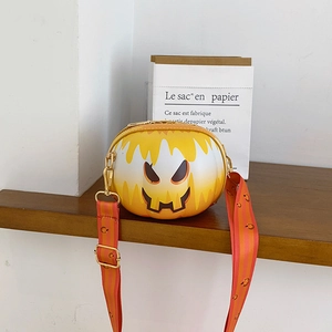 Detail of round pumpkin smiley crossbody bag with orange strap and gold hardware