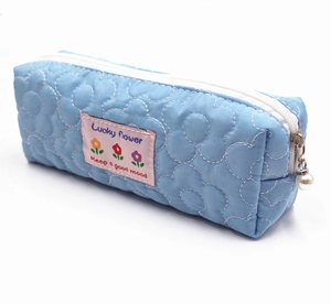 Detail of light blue quilted pencil case with white flower stitching and pearl zipper