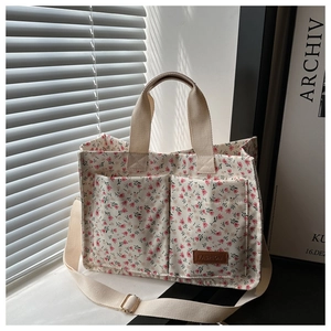 Detail of floral canvas tote bag with front pockets and elegant striped shadow lighting
