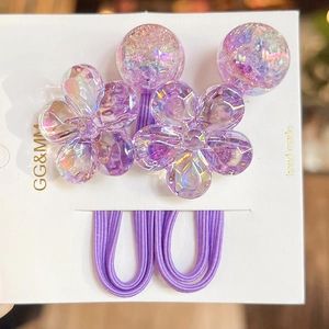 Close-up of purple camellia hair ties with holographic flower and bead details