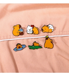 Detail of 6pcs Capybara enamel pins set with cute animals on orange fabric background