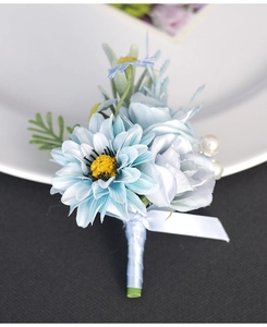 Macro detail of a light blue artificial rose boutonniere with white pearls and green leaves