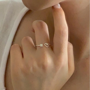 Close-up of a silver heart-shaped adjustable ring with a square zircon on a model hand