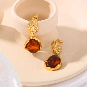 Vintage gold layered earrings with textured metal and amber resin pendants in elegant style