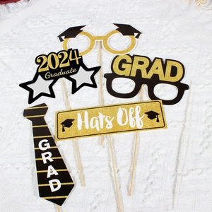 Detailed view of 2024 graduation photo props with gold and black paper accessories