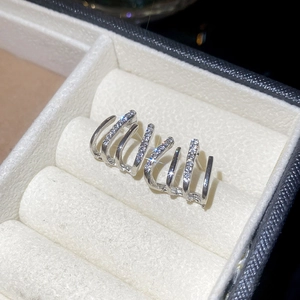 Macro shot of silver C-shaped double-layer earrings with sparkling zircon inlay