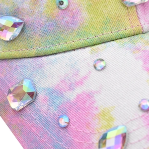 Detailed macro view of colorful tie-dye twill fabric with multi-shaped AB rhinestones