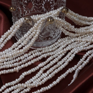 Perles d'eau douce naturelles 3-4mm présentées sur verre élégant et soie rouge