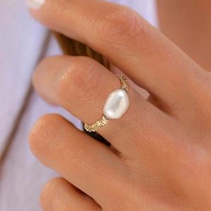 Detail of an 8.5mm baroque freshwater pearl on a gold textured chain-style silver ring
