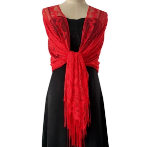 Detail of vibrant red lace shawl featuring delicate floral patterns and long fringe tassels