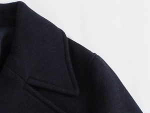 Macro shot of notch lapels and textured wool fabric stitching on a dark coat
