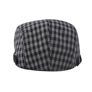 Detail of grey plaid newsboy cap showing fabric texture and metal buckle side strap