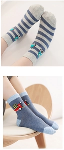 Detail of cotton baby socks featuring blue construction trucks and striped patterns