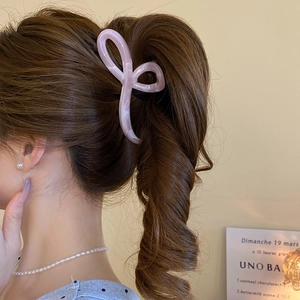Pink marble texture bow hair claw clip styled on a high ponytail for a sweet look