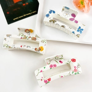 Detail view of three floral printed rectangular hair claw clips with resin finish