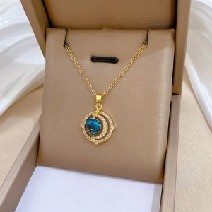 Détail du collier nuit étoilée de Van Gogh avec lune dorée et incrustation bleue