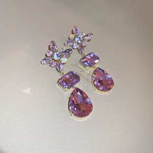 Detail of purple crystal drop earrings with vintage flower design in gold setting
