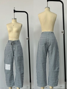 Detail of drawstring waist and geometric pockets on striped wide-leg pants