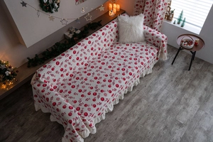Close-up of Christmas sofa cover with red candy patterns and elegant ruffle edges