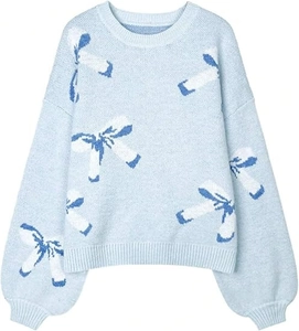 Detail of light blue knit sweater featuring delicate white and dark blue bow patterns