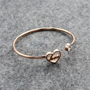 Close-up of rose gold stainless steel heart bracelet with Love engraving and zircon