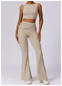 Detail of high-waisted yoga pants with ruched waistband and matching crop top in beige