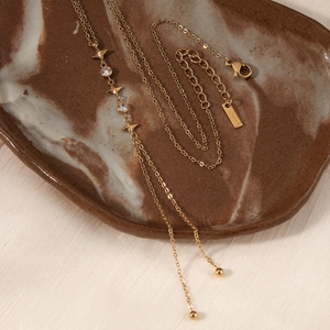 Golden stainless steel Y-shaped necklace with zircon star pendant on marble tray