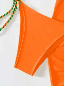 Detailed close-up of high-cut orange bikini with two-tone braided spiral tie strings