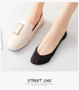 Close-up of black ice silk no-show socks worn with off-white buckle loafers for women