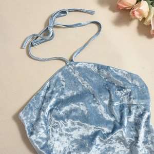 Detail van blauwe fluwelen haltertop met zachte glanzende textuur en hoogwaardig materiaal