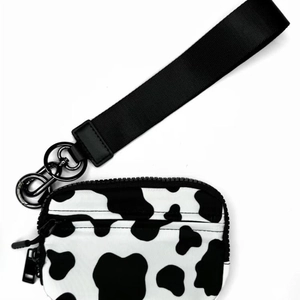Detail of cow print card holder pouch with wide black lanyard and matte metal spring clip