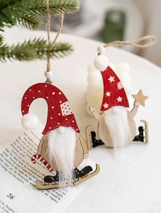 Detail of Nordic wooden gnome Christmas ornaments with plush beards hanging on tree branches