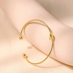 Elegant 18K gold-plated titanium knot C-shaped cuff bracelet with metallic ball ends