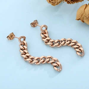 Macro detail of rose gold stainless steel Cuban chain drop earrings with butterfly backs